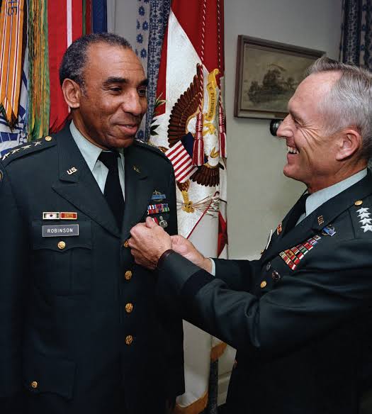 A fellow four-star general pins a decoration on Robinson. U.S. Army photo; photographer unknown.