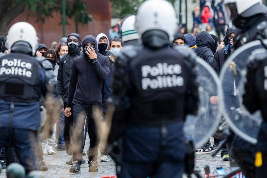 Belgium protest scene supplied by Stephen G. Hall: demonstrators facing police. Photographer, location, date and usage permission remain unverified.